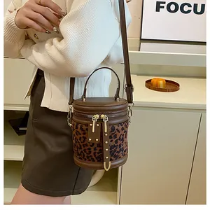 Detail of trendy leopard print bucket bag with gold hardware and dual zippers