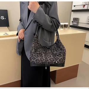 Detail of grey leopard print tote bag with black leather straps and leather bow accent