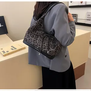 Detail view of leopard print tote bag with black bow decoration and leather shoulder strap