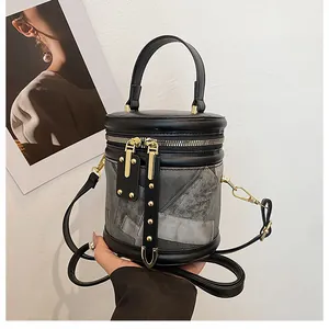 Detailed view of stylish bucket bag with marble texture, gold zippers and thick handle