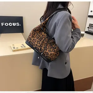 Close-up of leopard print tote bag featuring black leather trim and drawstring detail