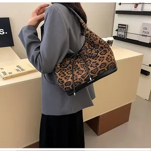 Detail of leopard print tote bag featuring a decorative bow and contrasting black leather base