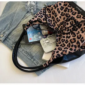 Detail of leopard print tote bag interior showing large capacity for tablet and cosmetics