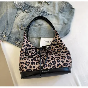 Detail of leopard print tote bag with black faux leather trim and ribbon bow detail