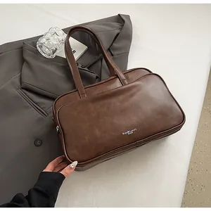 Detail shot of vintage brown synthetic leather texture and printed logo on Boston bag