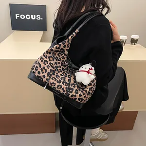 Contrast leopard print tote bag with black leather base and plush dog charm accessory