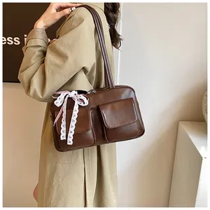 Detail view of large brown retro PU tote bag with twin pockets and lace bow decoration
