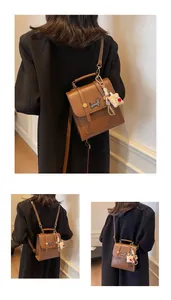 Brown leather crossbody backpack with dachshund embroidery and white bear charm detail