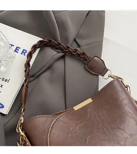 Nahaufnahme der dunkelbraunen Beuteltasche mit geflochtenem Griff und Golddetails