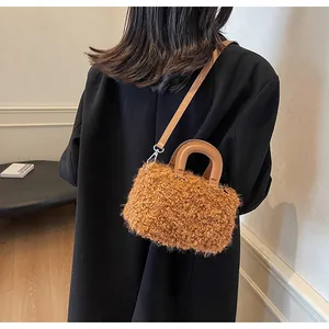 Detail of the brown faux shearling texture and leather handle on this mini crossbody bag