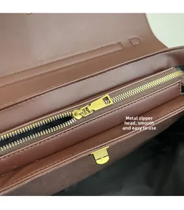 Macro della chiusura lampo in metallo dorato e della tasca interna in pelle marrone borsa