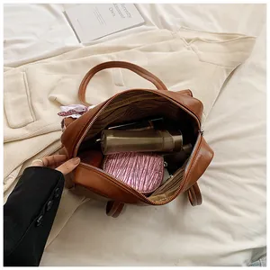 Top view of spacious brown tote interior holding cosmetics and daily essentials