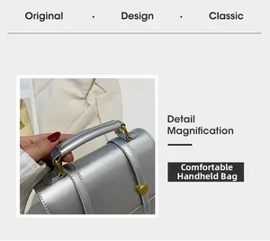Détail d'un sac en cuir argenté mat avec poignée supérieure confortable et boucles dorées