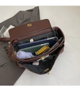 Vista interna di una grande borsa tote in pelle scamosciata marrone con molti scomparti
