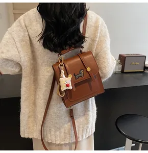 Detail of square brown leather backpack with dachshund embroidery and toast charm