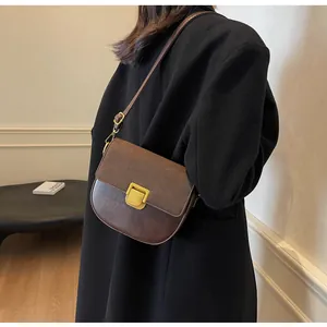 Dettaglio della borsa a sella marrone vintage con fibbia dorata e cuciture rifinite