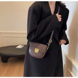 Dettaglio borsa a sella vintage in pelle marrone con fibbia dorata decorativa