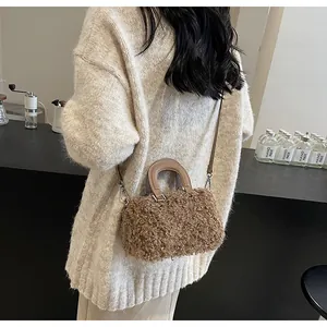 Detail view of brown faux wool box bag with leather handles and silver hardware accents