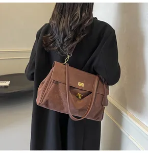 Dettaglio della borsa vintage in pelle scamosciata marrone con chiusura dorata