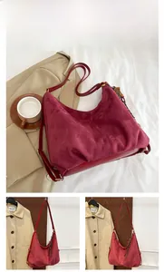 Detail of burgundy hobo bag showing suede texture, leather stitching and tassel