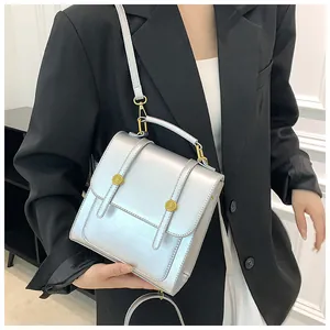 Détail du sac à main argenté métallisé avec boucles dorées et bandoulière amovible