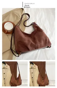 Detail view of large dark brown suede tote bag with woven tassel and gold hardware