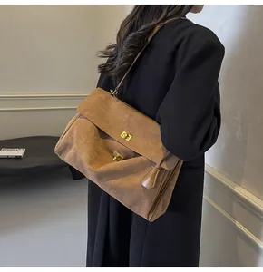 Dettaglio della borsa a spalla vintage in pelle smerigliata marrone con chiusure dorate
