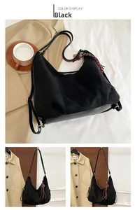 Detail view of black faux suede hobo bag with gold hardware and silk scarf accent