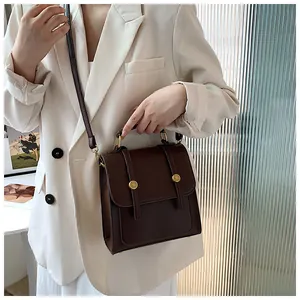 Détail du sac vintage en cuir marron avec boucles dorées et poignée de transport