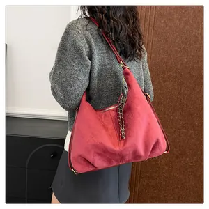 Detail of red suede hobo bag with adjustable strap and braided cord ornament
