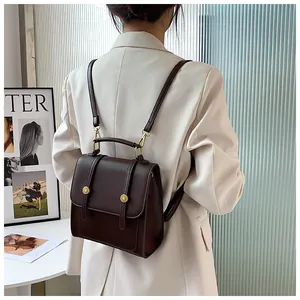 Détail d'un sac à dos vintage en cuir PU marron foncé avec boucles dorées en relief