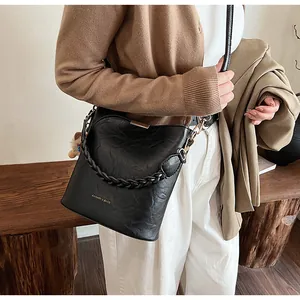 Detail einer schwarzen gewebten Beuteltasche mit Goldbeschlägen zum Freizeitoutfit