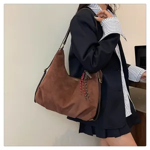 Detailed view of brown suede hobo bag with braided rope accent and adjustable strap