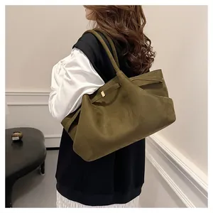 Dettaglio della grande borsa tote in pelle scamosciata verde oliva con spalline sottili ed oro