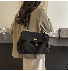 Dettaglio di una borsa vintage nera grande con chiusura girevole dorata in pelle opaca