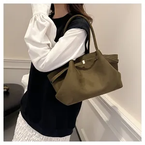 Dettaglio della borsa tote in pelle scamosciata verde oliva con design a pieghe dorate