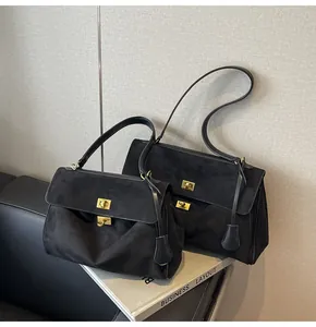 Dettaglio di borse tote in camoscio nero opaco con chiusure rotanti dorate in due misure