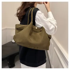 Dettaglio della borsa tote in pelle scamosciata verde oliva con spalline sottili e opache