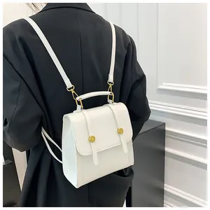 Détails d'un mini sac à dos blanc avec boucles en métal doré et poignée supérieure