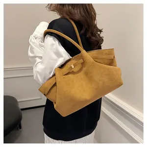 Grande borsa tote in pelle scamosciata senape su modella che mostra lo stile a spalla