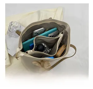 Interior view showing the large capacity and multi-compartment design of the cream tote bag