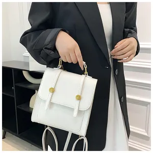 Détail du sac à dos blanc en cuir PU avec boucles en métal doré et poignées de transport