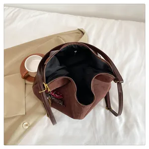 Top view of spacious interior in a brown matte suede tote bag with golden buckle detail