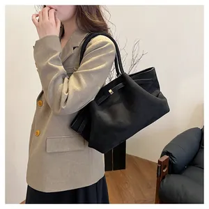 Dettaglio della borsa tote in pelle scamosciata nera opaca con cinturino e fibbia dorata