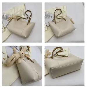 Detailed views of the off-white tote bag with brown straps and cute rabbit charm