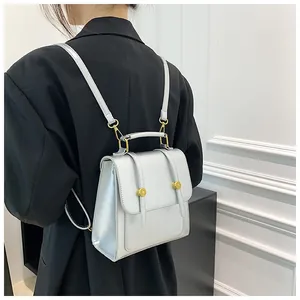 Sac à dos argenté métallisé avec rabat et détails dorés porté par un mannequin