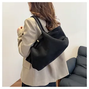 Dettaglio borsa tote nera opaca con texture scamosciata, fibbia in metallo e tracolla