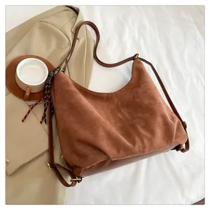 Detail of caramel suede hobo bag with checkered scarf accent and long shoulder straps