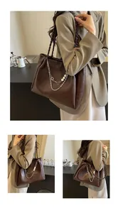 Detail of dark brown tote bag featuring woven straps and silver chain with pearl charms