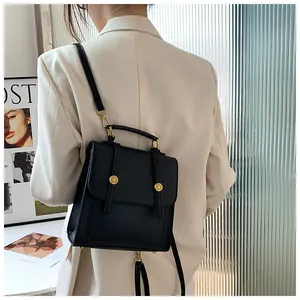 Vue détaillée d'un sac à dos noir en similicuir avec boucles dorées porté par un mannequin